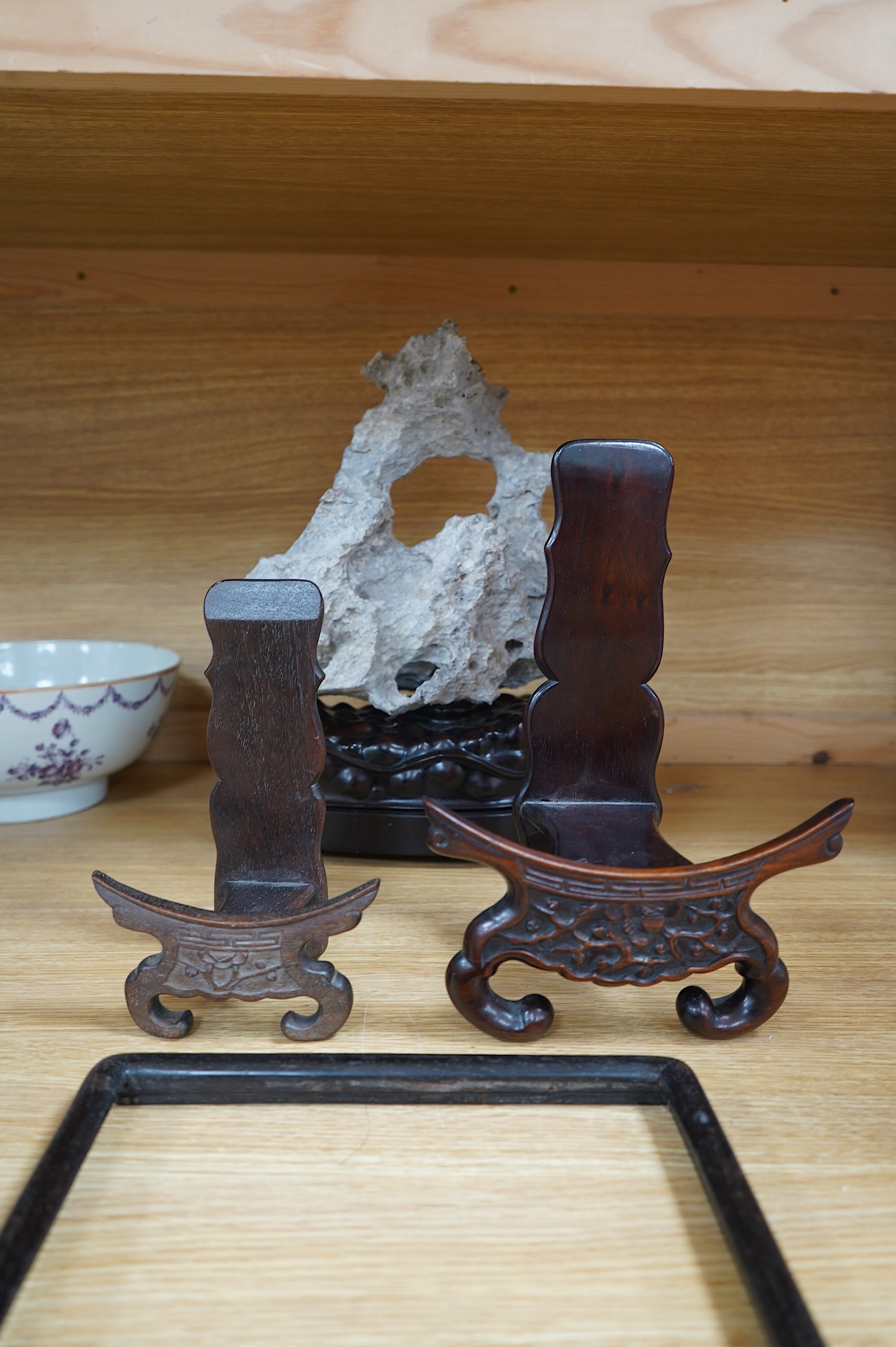 A Chinese grey stone scholar's rock, on stand, together with two Chinese hardwood plate stands and small hardwood frame, largest overall 38cm high. Condition - fair to good